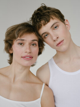 Young woman and androgynous man looking at camera