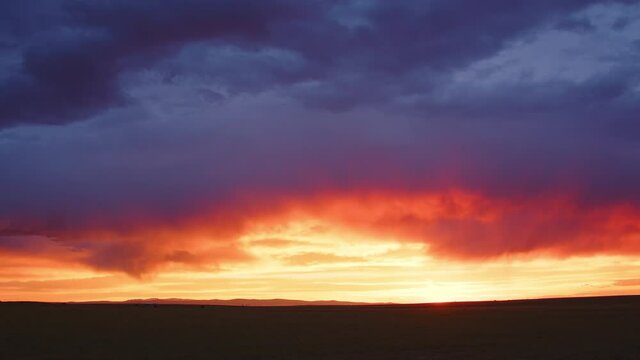 Sunset moving in timelapse over the flat landscape in Wyoming during the summer.