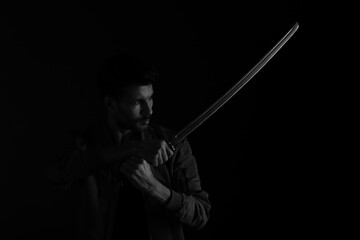 A man with katana sword in black and white