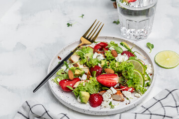 Summer fruit strawberry salad with chicken meat avocado, feta cheese, lettuce and nuts balsamic vinegar, concepts health food