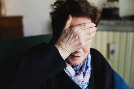 Elderly woman with hand on face