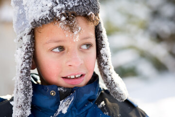 rosy cheeked boy with face full of snow