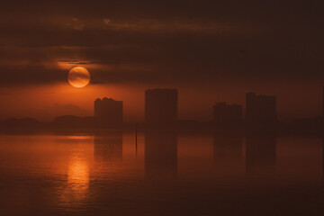 Dramatic Sunrise with Buildings and Dark Clouds