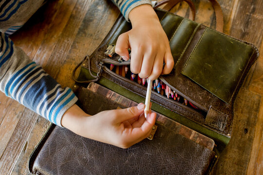 Child Pulls Pencil From Leather Case