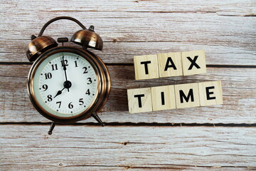 Tax Time with alarm clock with space copy on wooden background