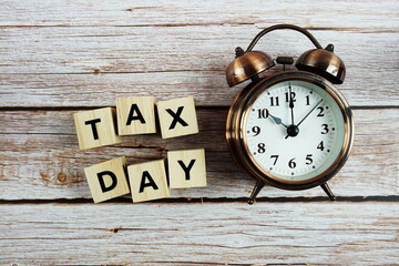 Tax Day Word alphabet letter And Alarm Clock on wooden background