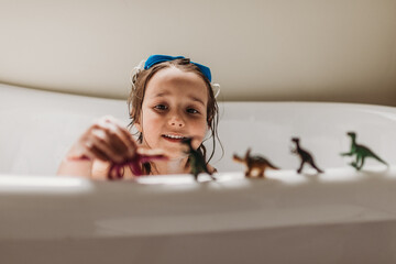 Girl and her toys in bubble bath