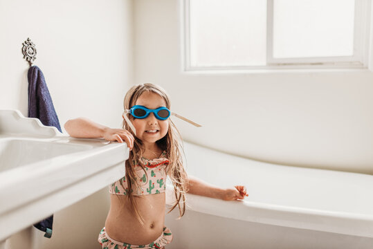 Girl with goggles standing in bathroom