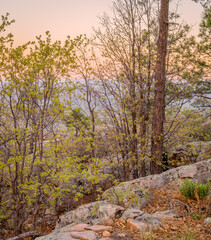 In Payson, Arizona this is known as the Mogollon Rim. The sun sets looking out over the rim, through the trees, the colorful sky paints the ledge and flowing hills, boulders and trees colorful shades 