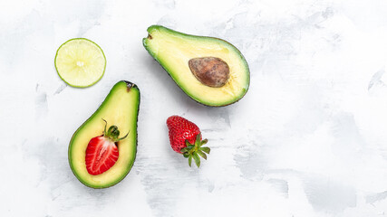 Avocado cut half and slice with strawberry on white background. clean eating for weight loss. banner, menu recipe place for text, top view