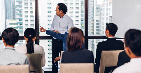 Fototapeta premium Businessman coach speaker presentation and discussing meeting strategy sharing idea.Creative team casual business people seminar and brainstorm in conference seminar at hall.presentation and teamwork