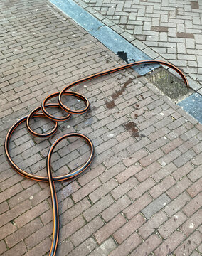 hose going into sidewalk gutter