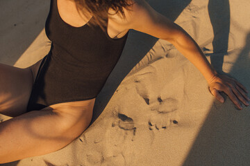 Woman at the beach sitting on the sand