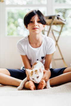 Teen holding upset kitty in pose