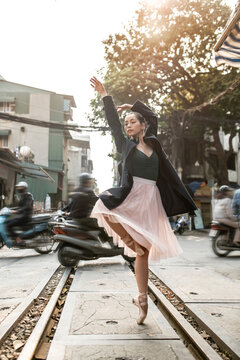 Female ballet dancer is posing outdoors in city