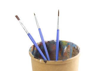 Paper cup and brushes in acrylic paints. Close up. Isolated on a white background
