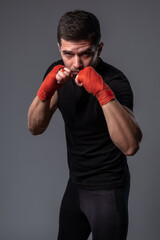 Man with wrist wraps on hands standing in orthodox boxing stance