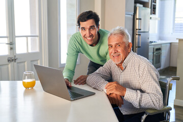 Junger Mann und Senior haben Spaß am Laptop Computer
