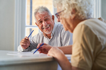 Senioren Paar beim Rätsel lösen als Beschäftigungstherapie