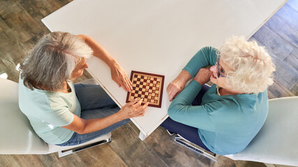 Zwei Senior Frauen im Ruhestand beim Dame spielen
