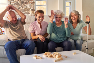 Senioren in Familie spielen Jenga bei Spieleabend