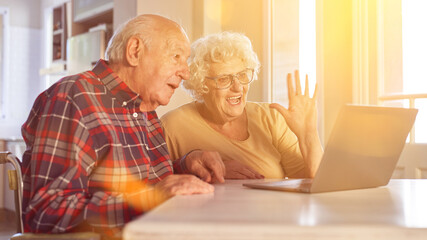 Paar Senioren winkt beim Videochat am Computer