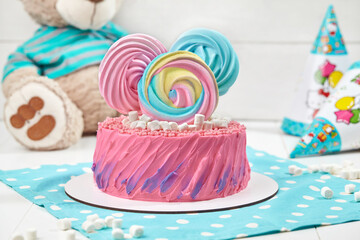Pink cake with meringue figures and marshmallow