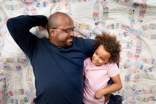 Father and daughter on quilt
