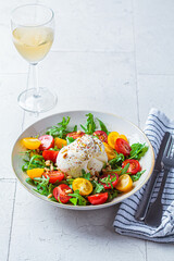 Burrata cheese salad with arugula and tomatoes.