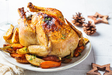 Close-up of christmas baked whole chicken stuffed with thyme, lemon and vegetables.