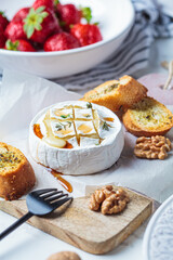 Baked Camembert or Brie with thyme and maple syrup. Cheese, fruits, bread and nut to white wine.