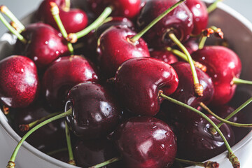 Fresh summer cherries in gray bowl, close-up.