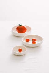 Fresh red tomatoes in white plate on white table