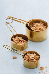 Ingredients in measuring cups and in measuring spoons with rolled oats