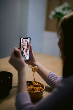 Girl having online conversation during dinner