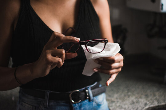Woman cleaning her glasses