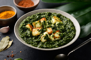 Palak Paneer indian traditional food with cheese and spinach on black background, selective focus