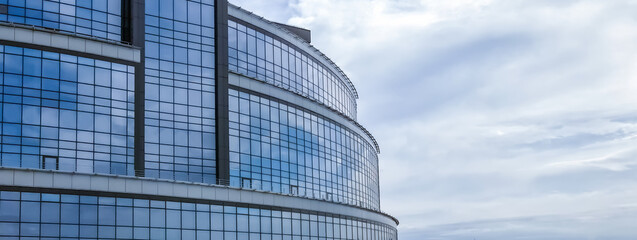 Fototapeta premium fragment of an office building tower skyscraper against the blue sky panorama