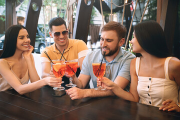 Friends with Aperol spritz cocktails resting together at restaurant