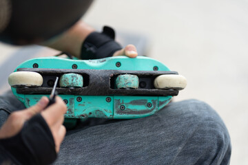 person repairing inline skates damaged by time of use