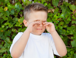 Blond little boy rubbing eyes