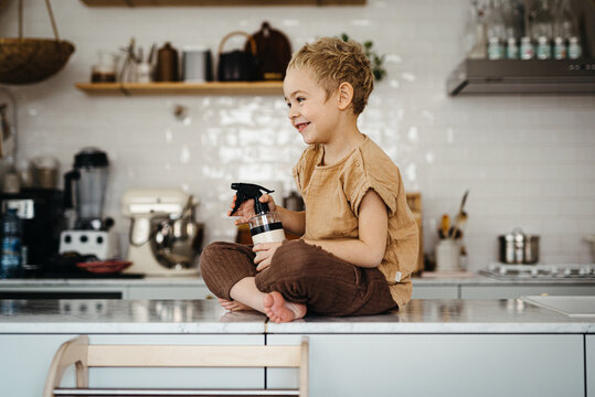 toddler boy helping out with house chores and cleaning