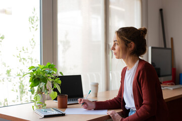 Teenager girl doing homework in her home