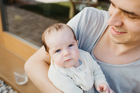 Portrait of cute newborn in the arms of her father