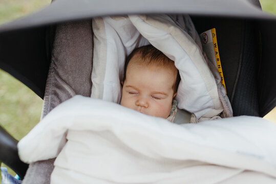 Portrait of cute newborn sleeping in a baby carriage