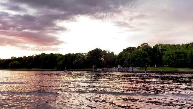 The river bank at sunset in summer. Summer landscape on the river bank. 4K video.