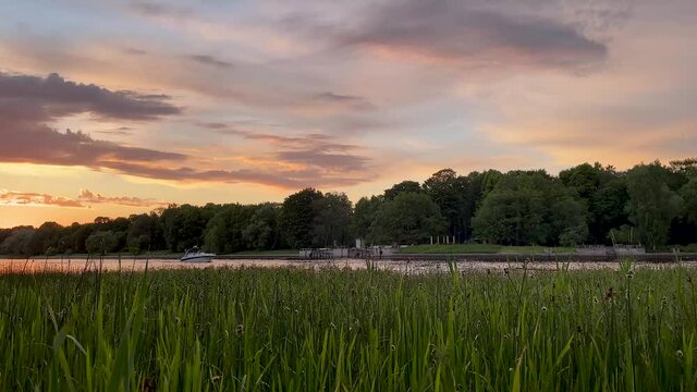 The river bank at sunset in summer. Summer landscape on the river bank. 4K video.