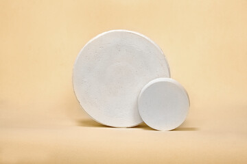 Empty white  podium on pastel beige color background. Minimal boxes and geometric podium. Scene with geometrical forms. Empty showcase for cosmetic product presentation. Fashion magazine.