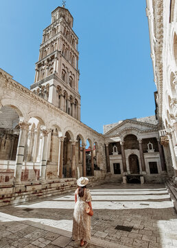 Woman in stylish summer dress standing in Peristyle of Diocletian's palace in Split, Croatia.