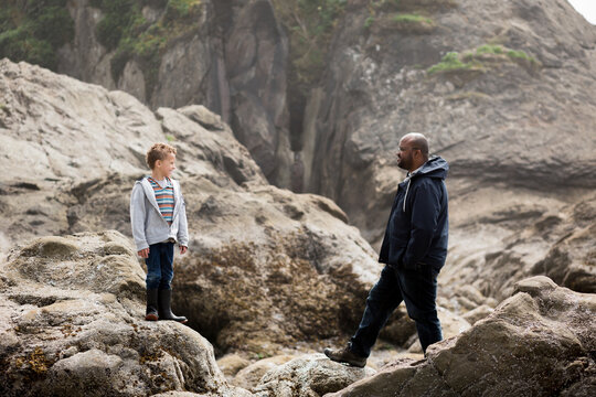 Father and son on rocks at beach